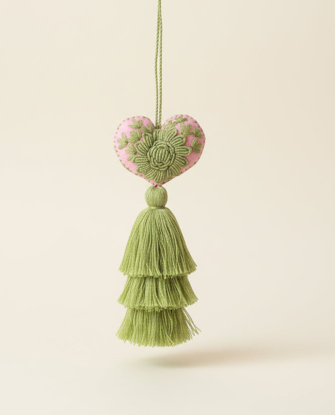 Decorative heart-shaped tassel with floral design on a dark gray background